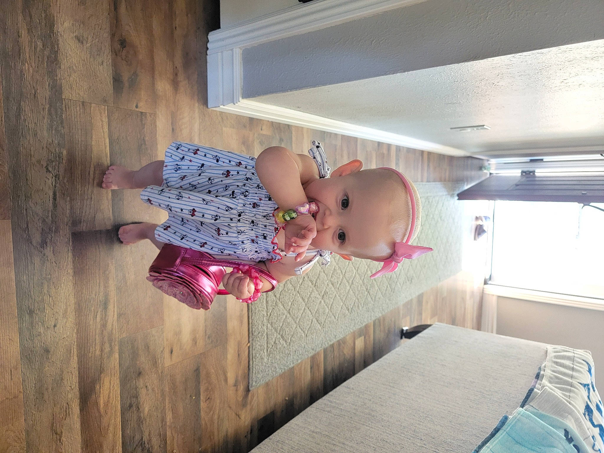Emma is registered to the contest to win money with this photo: baby, baby_products, baby_safety, baby_toddler_clothing, ceiling, child, comfort, floor, flooring, hardwood, house, linens, magenta, pattern, person, room, sitting, toddler, wood