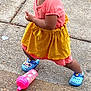 blue_shoes, casual_clothing, child, concrete, cute, expression, footwear, fun, hair_pigtails, outdoor, pavement, person, pink_top, playful, pose, sippy_cup, summer, toddler, yellow_skirt, young_child