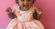 Kiyomi is registered to the contest to win money with this photo: baby, bow, child, clothing, curly_hair, cute, face, fashion, girl, hands, happy, indoor, infant, pink_background, pink_dress, portrait, shoes, sitting, smiling, toddler