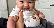 Coast joined the competition — help win amazing prizes! baby, child, person, indoor, smile, hand, clothing, onesie, animal_print, hair, face, cute, expression, holding, door, furniture, sitting, happy, portrait, skin