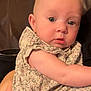 arm, baby, blue_eyes, child, closeup, couch, cute, ear, expression, face, floral_outfit, hand, indoors, infant, looking, patterned_cushion, person, sitting, skin, young