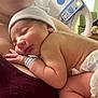 Ravi is registered to the contest to win money with this photo: newborn, baby, sleeping, hospital, adult, skin, hat, diaper, hand, face, closeup, rest, mother, hospital_bed, arm, person, indoors, comfort, tenderness, care