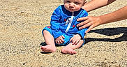 Kaiden Kopas joined the competition — help win amazing prizes! baby, barefoot, beach, blue_clothing, child, clouds, hands, lake, nature, outdoor, person, sand, sitting, sky, summer, sunlight, support, swimsuit, trees, water