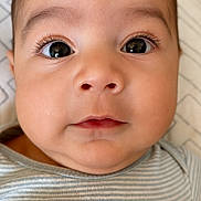 Matthew joined the competition — help win amazing prizes! baby, infant, face, eyes, skin, clothing, striped, pillow, portrait, closeup, child, cute, expression, head, person, young, indoors, resting, soft, neutral_background