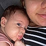 baby, infant, adult, face, closeup, skin, expression, cuddle, bonding, striped_clothing, person, head, earring, cheek, hand, mouth, eye, indoor, comfort, family