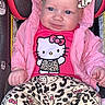 baby, child, car_seat, pink_jacket, headband, hello_kitty, leopard_print, clothing, infant, cute, portrait, smiling, sitting, indoors, person, baby_clothes, accessory, fashion, young_child, apparel