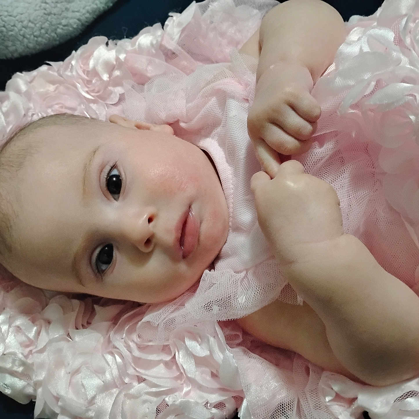 Angelic is registered to the contest to win money with this photo: adorable, baby, child, closeup, cute, expression, fabric, face, hand, indoors, infant, lying_down, newborn, pink_dress, portrait, resting, ruffled_blanket, skin, small_fingers, soft_texture