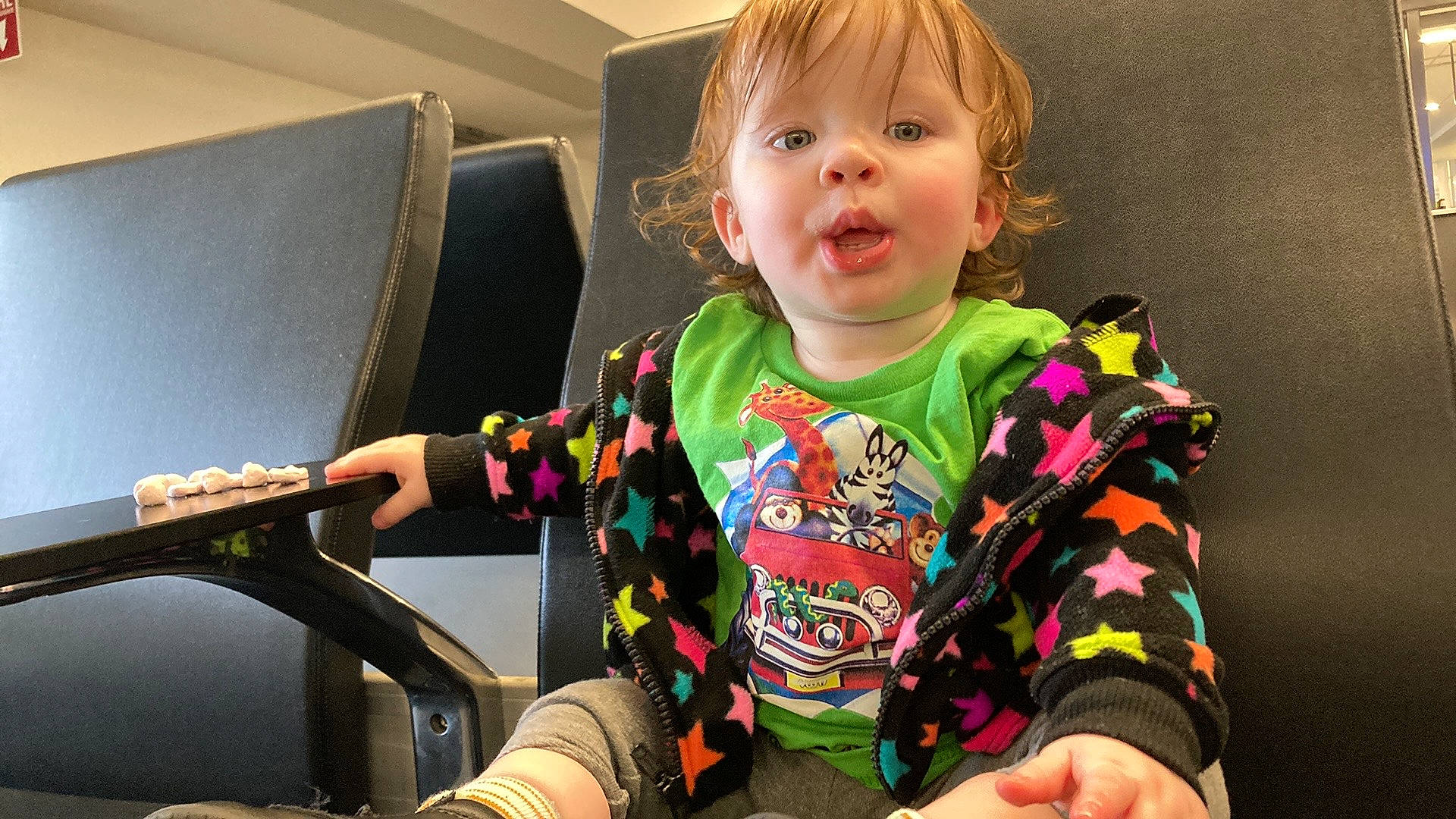 Marie is registered to the contest to win money with this photo: auto_part, baby, baby_toddler_clothing, car_seat, cheek, child, comfort, finger, fun, happy, iris, person, personal_protective_equipment, room, sitting, sleeve, smile, t_shirt, thumb, toddler