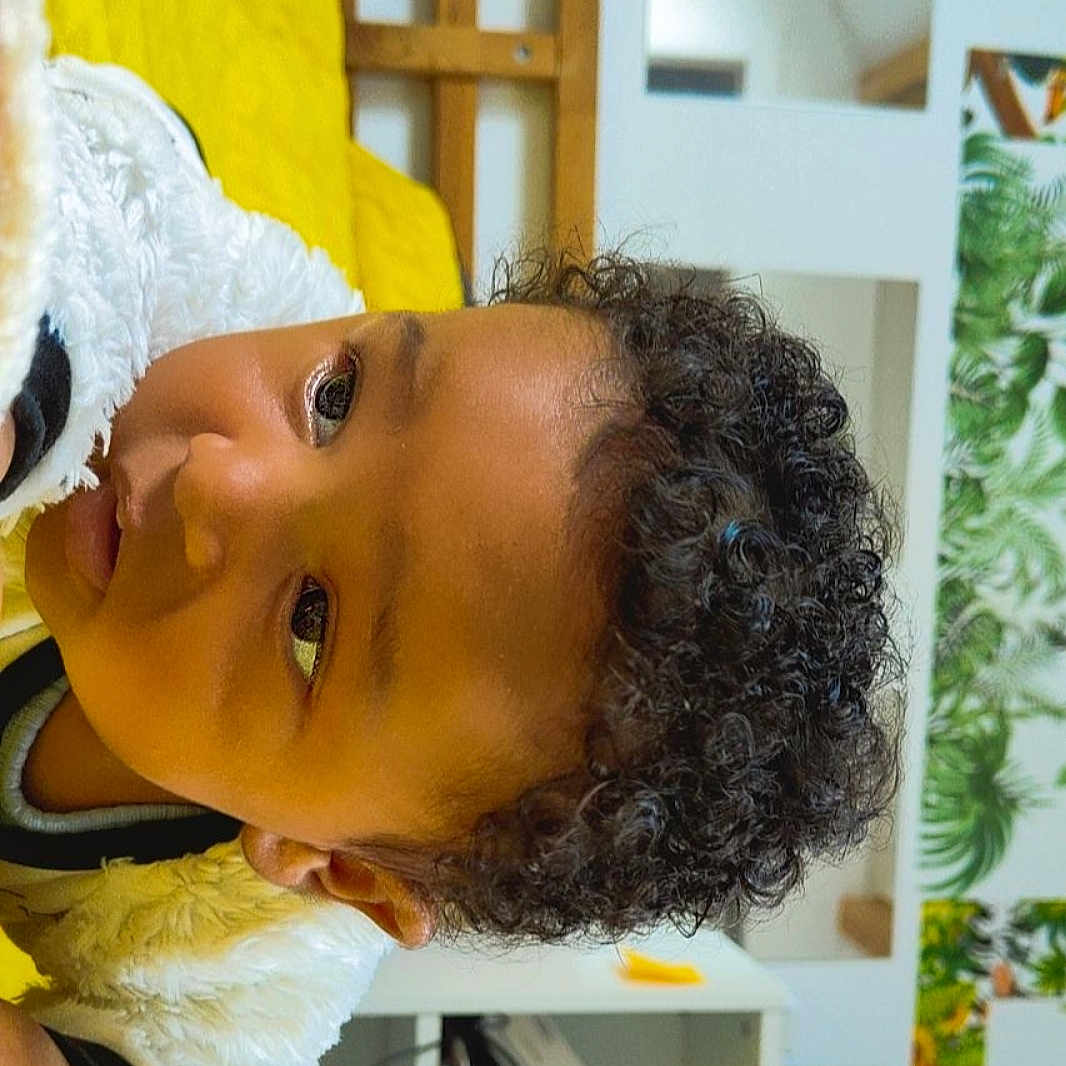 Lowen participe au concours pour gagner de l'argent avec cette photo : casual, child, close_up, cozy, curious, curly_hair, expression, face, furniture, greenery, head, indoor, modern_room, person, portrait, skin, wall_art, white_jacket, yellow_blanket, young_child