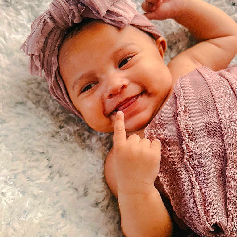 Ivory is registered to the contest to win money with this photo: baby, babylaughing, bodypart, bonnet, cap, clothing, dimples, dress, face, finger, hand, happy, hat, head, laughing, newborn, person, photography, portrait, smile