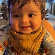 Stetson joined the competition — help win amazing prizes! baby, child, smile, indoor, cozy, bib, clothing, curly_hair, face, happy, person, portrait, infant, cute, warm_lighting, home, expression, young, sitting, closeup