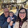 Noah participe au concours pour gagner de l'argent avec cette photo : family, baby, man, woman, glasses, smile, outdoor, park, bench, trees, daylight, people, urban, jacket, coat, child, portrait, happy, holding, casual