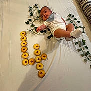 Noah a rejoint le concours — aidez-le/la à gagner de superbes lots ! baby, bed, blanket, cookies, ivy, leafy_plants, milestone, number, person, plant, pose, sock, soft_toys, toddler, white_clothing, youth, indoor, cushion, decor, celebration