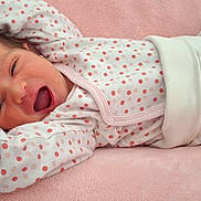 Mya participe au concours pour gagner de l'argent avec cette photo : baby, newborn, infant, sleepwear, pajamas, polka_dot, pink, white, blanket, stretching, yawning, lying_down, cozy, cute, soft, child, person, indoors, resting, portrait