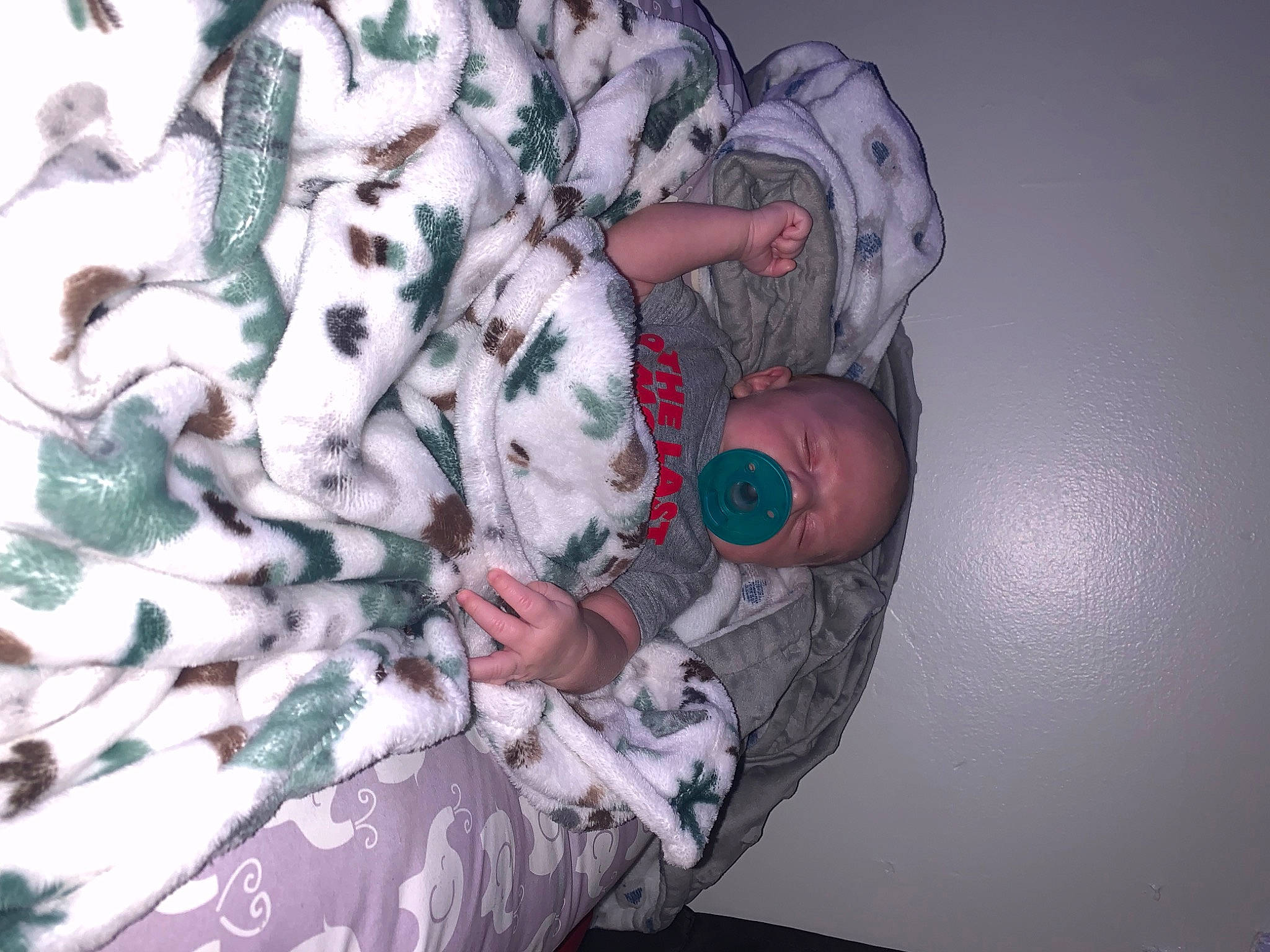 Kooper is registered to the contest to win money with this photo: baby, carmine, child, finger, fur, gesture, human_leg, linens, military_camouflage, nail, pattern, person, pink, plant, room, sleeve, stuffed_toy, textile, thigh, toy