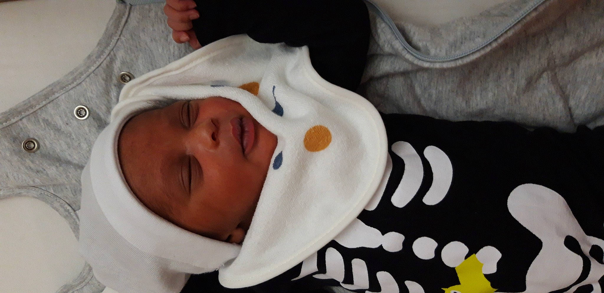 Djayeed participe au concours pour gagner de l'argent avec cette photo : baby, baby_toddler_clothing, cheek, comfort, ear, eye, eyebrow, eyelash, finger, gesture, hat, headgear, headwear, linens, lip, mouth, neck, nose, person, sleeve