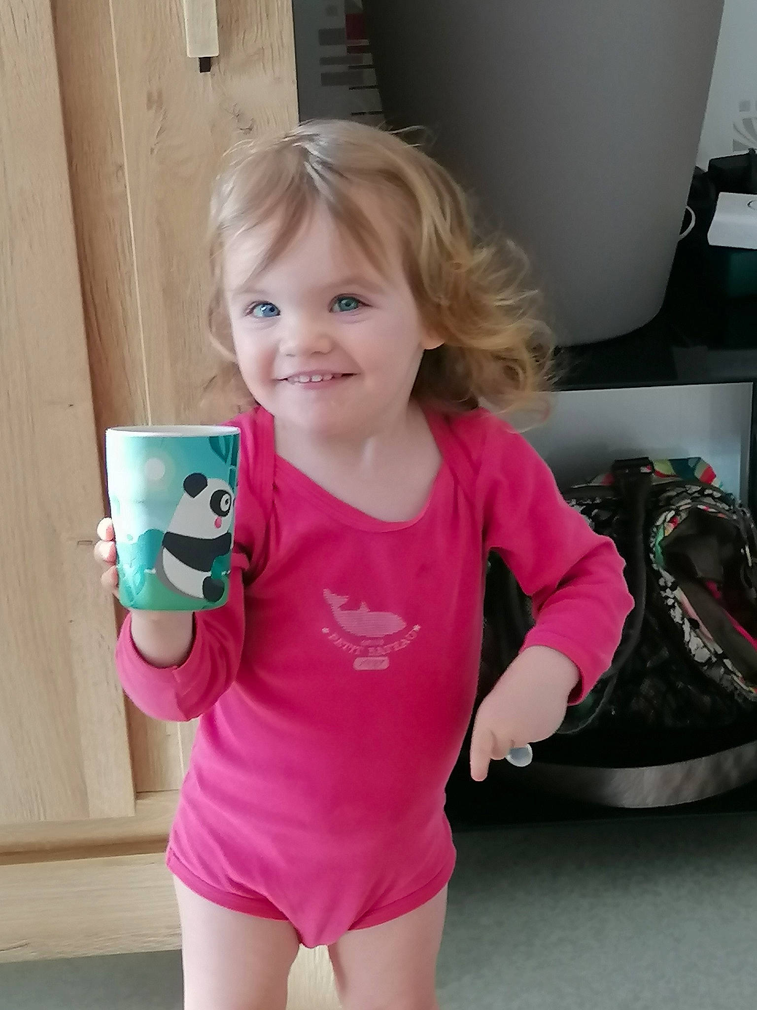 Zoé participe au concours pour gagner de l'argent avec cette photo : baby_toddler_clothing, clothing, coffee_cup, drinkware, eye, facial_expression, finger, hairstyle, happy, head, human_body, joy, neck, person, pink, shoulder, sleeve, smile, standing, t_shirt