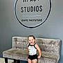 Amelia joined the competition — help win amazing prizes! advertisement, blonde, child, clothing, couch, face, female, footwear, furniture, girl, hair, head, person, photography, portrait, shoe, shorts, sitting, sleeve, table