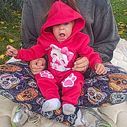 Catherine joined the competition — help win amazing prizes! baby, child, infant, pink_hoodie, hooded_sweatshirt, hello_kitty, sitting, adult, parent, hands, surprised, open_mouth, portrait, outdoor, grass, dandelions, fallen_leaves, cushion, patterned_fabric, sneakers