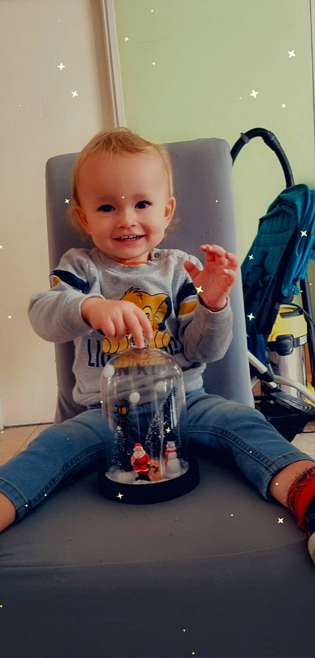 Andréas participe au concours pour gagner de l'argent avec cette photo : baby, baby_toddler_clothing, bag, child, clothing, comfort, drinkware, flooring, fun, happy, human_leg, jeans, joy, knee, person, play, product, sitting, sleeve, smile