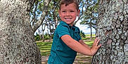 Adrian joined the competition — help win amazing prizes! child, boy, smiling, tree, outdoor, nature, park, greenery, sunlight, grass, clothing, shorts, shirt, playful, happy, daylight, trunk, leaves, young, casual