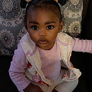Stormi joined the competition — help win amazing prizes! toddler, child, girl, indoor, couch, pillow, pattern, pink_clothing, vest, sitting, cute, portrait, young_child, hair_buns, expression, face, person, home, cozy, curious