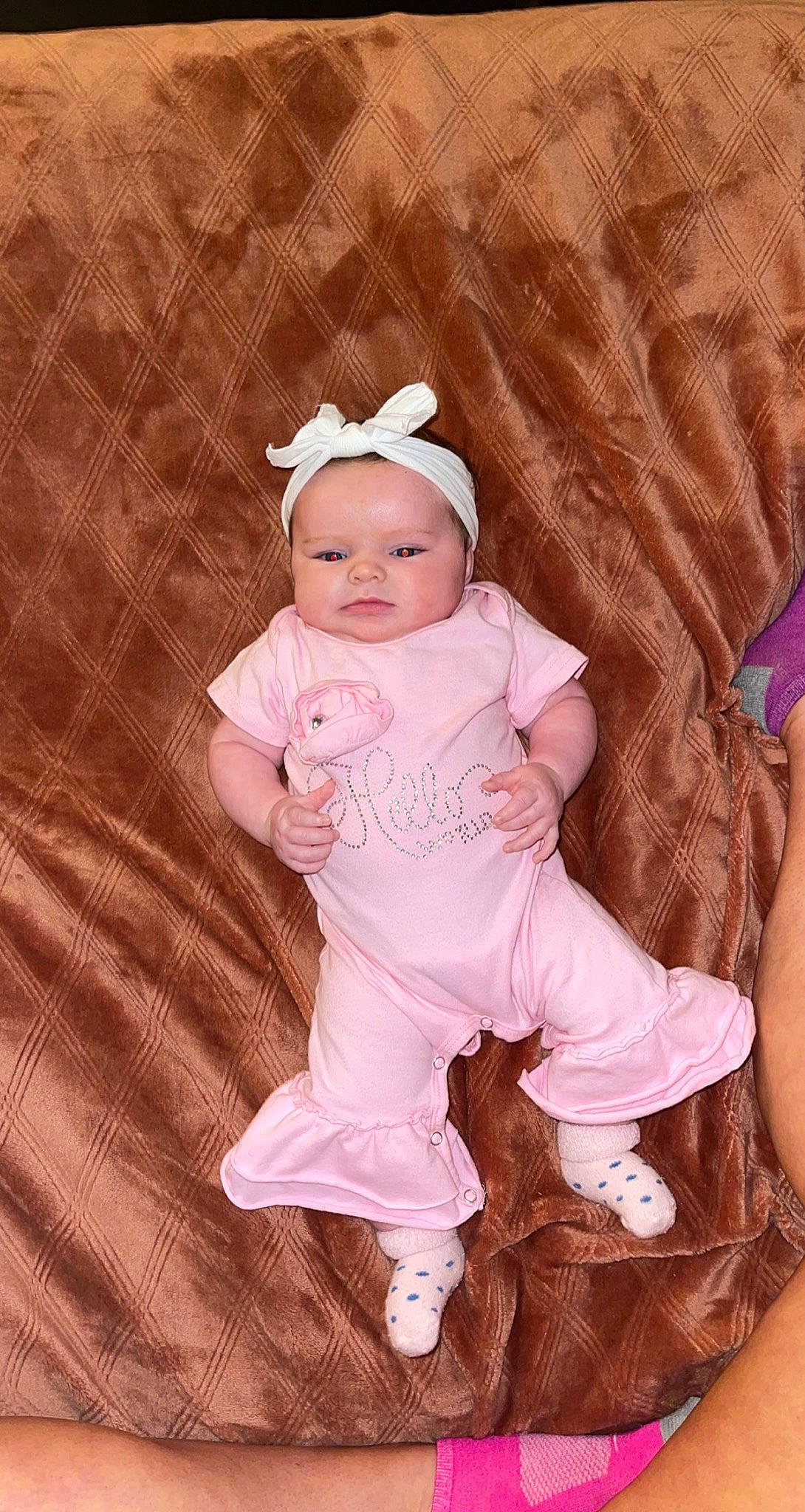 Stormi is registered to the contest to win money with this photo: baby, baby_products, baby_toddler_clothing, cheek, child, eye, fashion_accessory, fun, hair_accessory, happy, headband, headwear, linens, magenta, pattern, peach, person, pink, sitting, skin