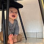 Liam participe au concours pour gagner de l'argent avec cette photo : toddler, child, baby, smiling, laughing, striped_shirt, pants, barefoot, floor, tile, chair, chair_legs, indoor, wall, playful, happy, sitting, person, young_child, cute