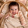 baby, infant, smiling, portrait, basket, blanket, plush_toy, teddy_bear, cozy, cute, indoors, soft_lighting, nursery, bedding, hand, eyes, warm_colors, smile, blanket_texture, portrait_photography