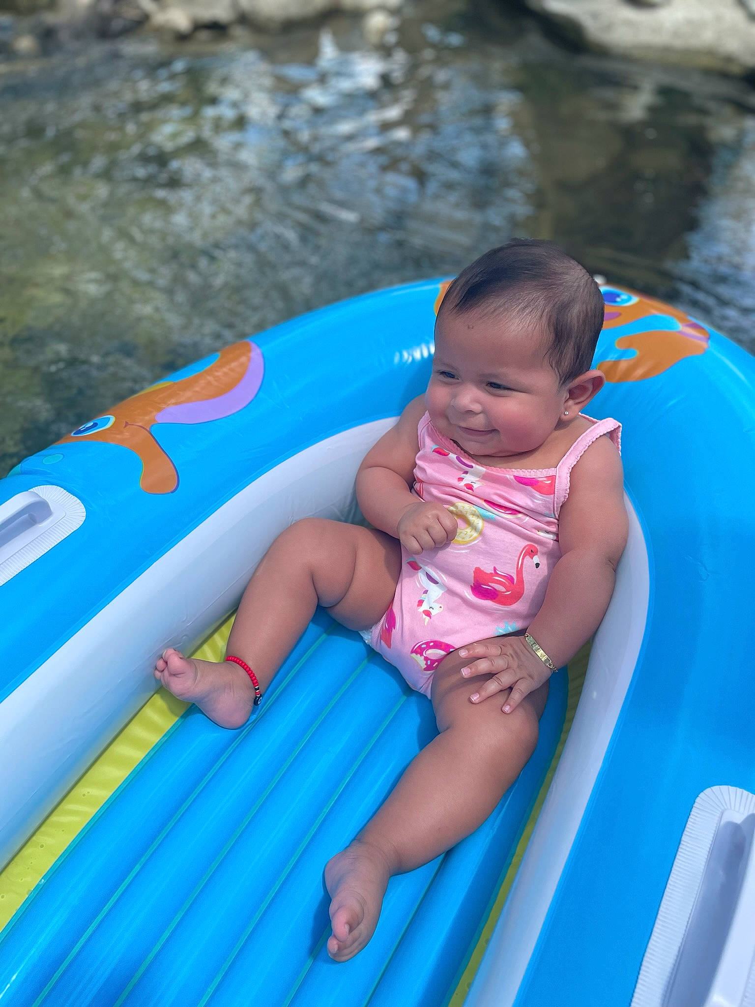 Celeste is registered to the contest to win money with this photo: aqua, azure, baby, baby_float, baby_toddler_clothing, blue, child, fun, games, happy, inflatable, leisure, outdoor_recreation, person, personal_protective_equipment, pink, recreation, swimming_pool, thigh, toddler