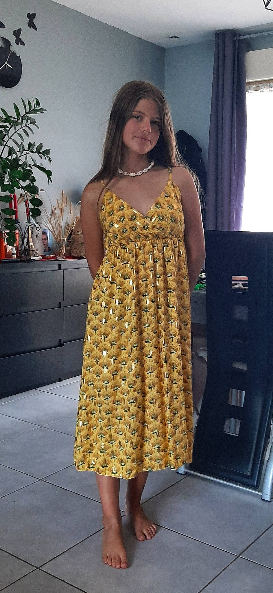 Tina participe au concours pour gagner de l'argent avec cette photo : black_hair, curtain, day_dress, dress, event, fashion_design, fashion_model, flooring, formal_wear, hair, houseplant, human_leg, long_hair, one_piece_garment, person, shoulder, sleeve, smile, thigh, trunk