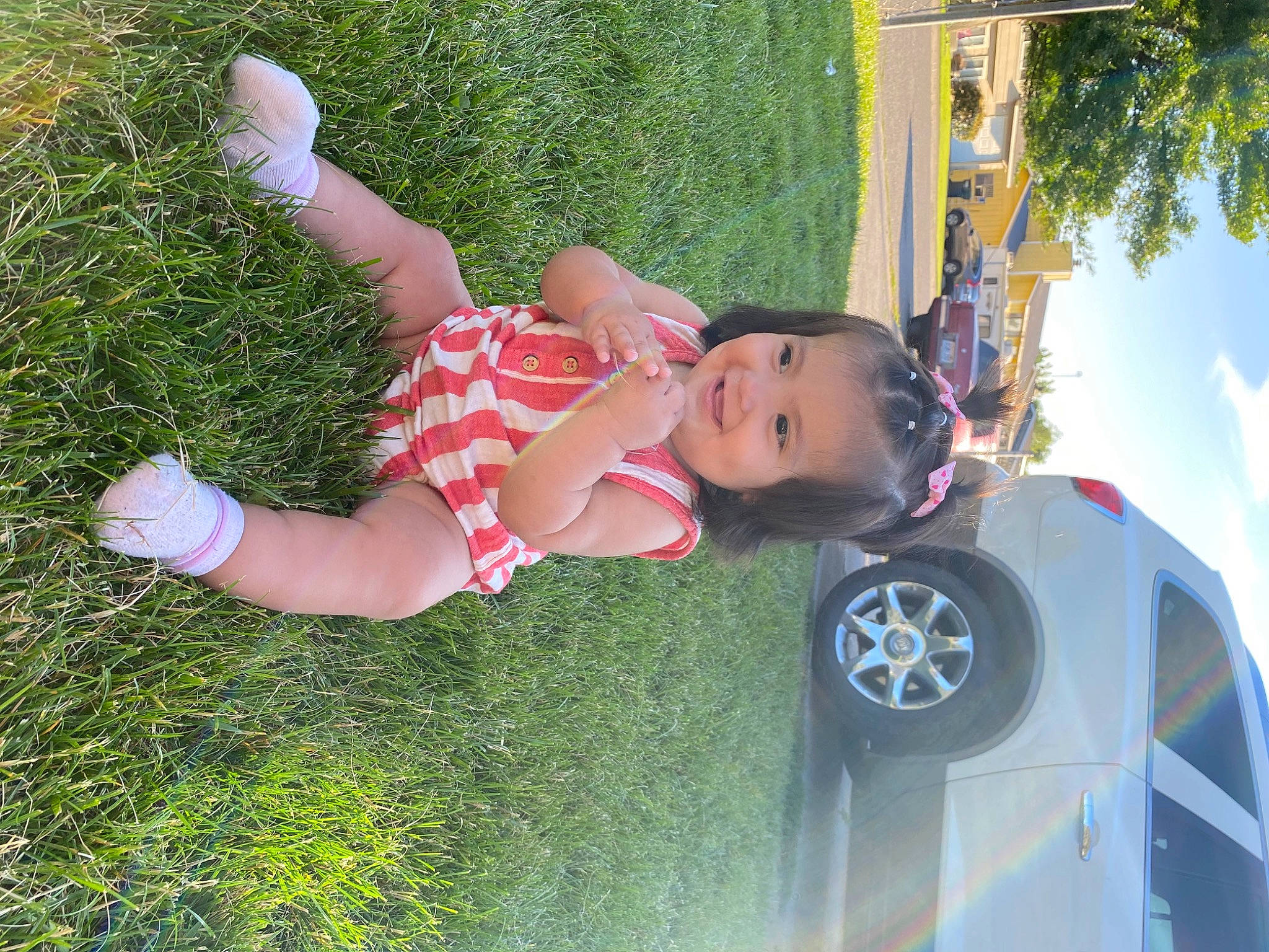 Milani is registered to the contest to win money with this photo: alloy_wheel, automotive_lighting, automotive_tire, bumper, car, fender, fun, grass, hood, joy, leisure, motor_vehicle, people_in_nature, person, plant, tire, toddler, tree, vehicle, vehicle_door