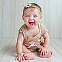 baby, child, smiling, headband, flower, sitting, floor, happy, cute, infant, portrait, hands, feet, clothing, indoor, person, skin, young, cute_outfit, joy