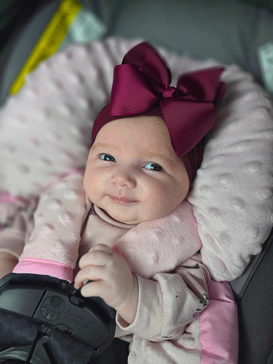 Shaylee joined the competition — help win amazing prizes! baby, infant, child, car_seat, safety_harness, pink_bow, headwear, soft_cushion, smile, cute, portrait, indoors, clothing, hand, face, eyes, baby_girl, comfort, seatbelt, closeup