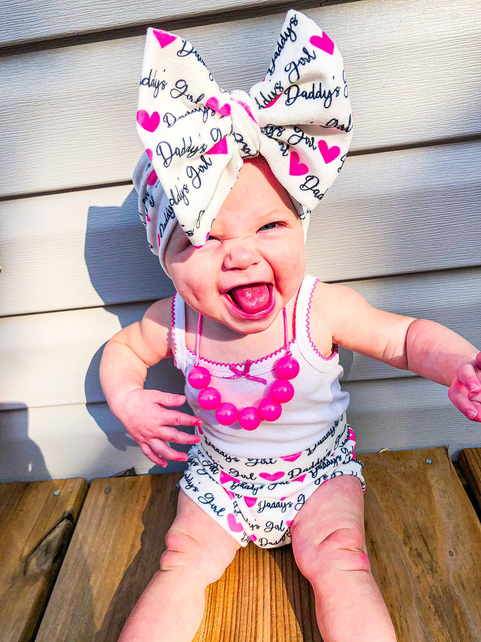 Kristen is registered to the contest to win money with this photo: baby_toddler_clothing, barefoot, baseball_cap, beanie, cap, child, costume, costume_hat, fashion_accessory, foot, fun, grass, happy, headwear, magenta, person, pink, sleeve, smile, t_shirt