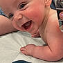 baby, smiling, child, infant, face, cheeks, skin, arm, hand, medical_table, phone, photo, reflection, adult, background, happy, closeup, expression, person, healthcare