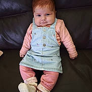 Gamora participe au concours pour gagner de l'argent avec cette photo : baby, child, clothing, cute, denim_dress, eyes, face, footwear, furniture, hands, indoor, infant, leather_couch, legs, pink_clothing, portrait, red_hair, sitting, smile, white_booties