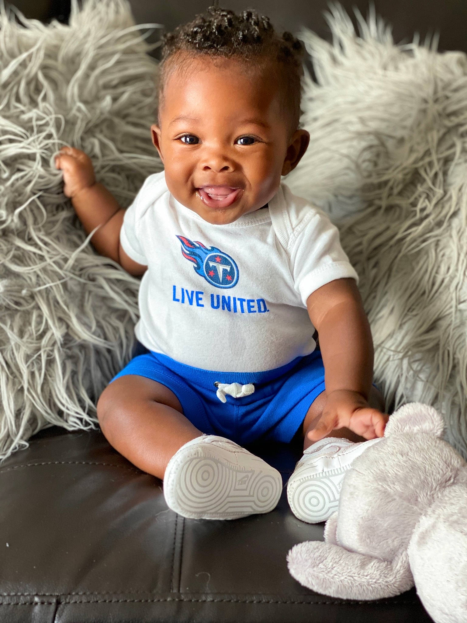 Kenton is registered to the contest to win money with this photo: arm, baby, baby_products, baby_toddler_clothing, blue, child, child_model, flooring, footwear, fur, joy, leg, person, photography, play, product, shoe, sitting, smile, t_shirt