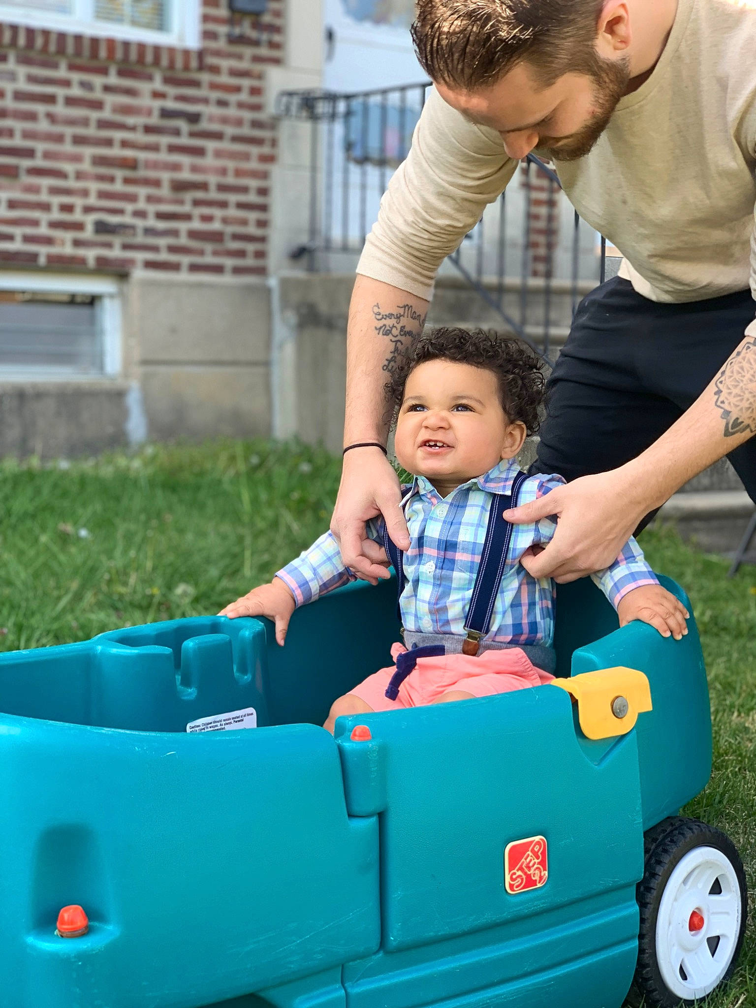 Elijah is registered to the contest to win money with this photo: arm, automotive_design, automotive_exterior, bumper, car, electric_blue, fun, grass, green, happy, leisure, motor_vehicle, person, recreation, shorts, sitting, tire, toddler, travel, vehicle