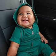 Santiago is registered to the contest to win money with this photo: baby, child, smiling, green_hoodie, car_seat, happy, infant, cute, portrait, sitting, indoors, clothing, hood, young_child, person, skin, seat, car_interior, expression, joy