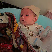 Zaiden joined the competition — help win amazing prizes! baby, blanket, hat, indoor, infant, onesie, soft_toy, wall, bed, sleepwear, child, cute, cozy, person, portrait, resting, young, comfort, fabric, toy