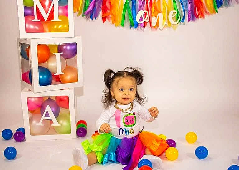 Mia is registered to the contest to win money with this photo: baby, baby_playing_with_toys, baby_toddler_clothing, baby_toys, child, event, fun, happy, magenta, party_supply, person, photograph, plastic, play, product, room, shelving, smile, toddler, toy