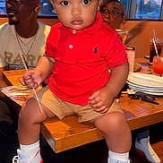Keion is registered to the contest to win money with this photo: adults, casual, child, drink, fashion, glasses, indoor, people, plate, portrait, red_cap, red_polo, restaurant, seated, shorts, sneakers, table, toddler, window, wooden_table
