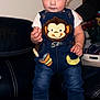 Julian joined the competition — help win amazing prizes! toddler, child, denim_overalls, monkey_patch, boots, leather_couch, indoor, person, cute, smiling, hand, standing, clothing, baby, denim, footwear, portrait, young_child, home, support