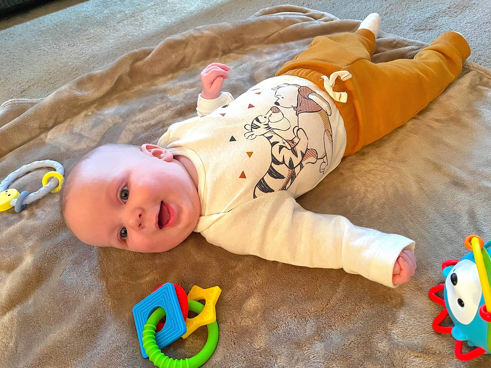 Carson is registered to the contest to win money with this photo: baby, baby_products, baby_toddler_clothing, baby_toys, child, comfort, flooring, fun, happy, linens, orange, pattern, person, play, room, sleeve, smile, textile, toddler, toy