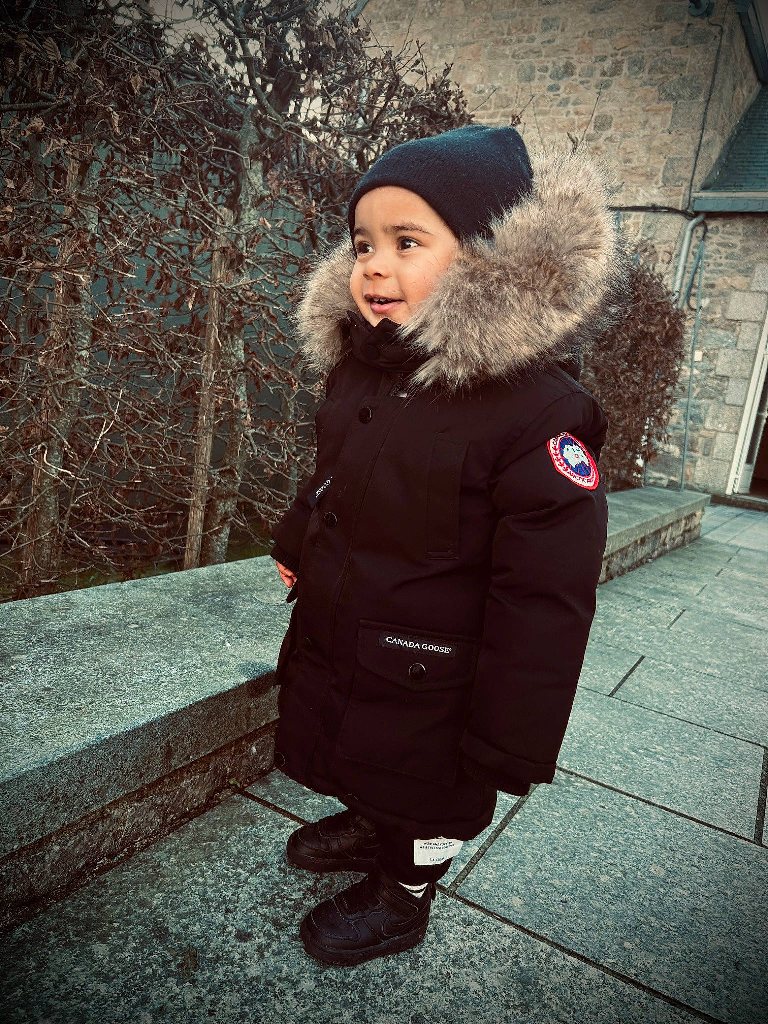 Amaël a rejoint le concours — aidez-le/la à gagner de superbes lots ! boot, cap, clothing, cool, electric_blue, flash_photography, fur, fur_clothing, headwear, human_leg, jacket, outerwear, overcoat, person, road_surface, smile, standing, street, tints_and_shades, tree