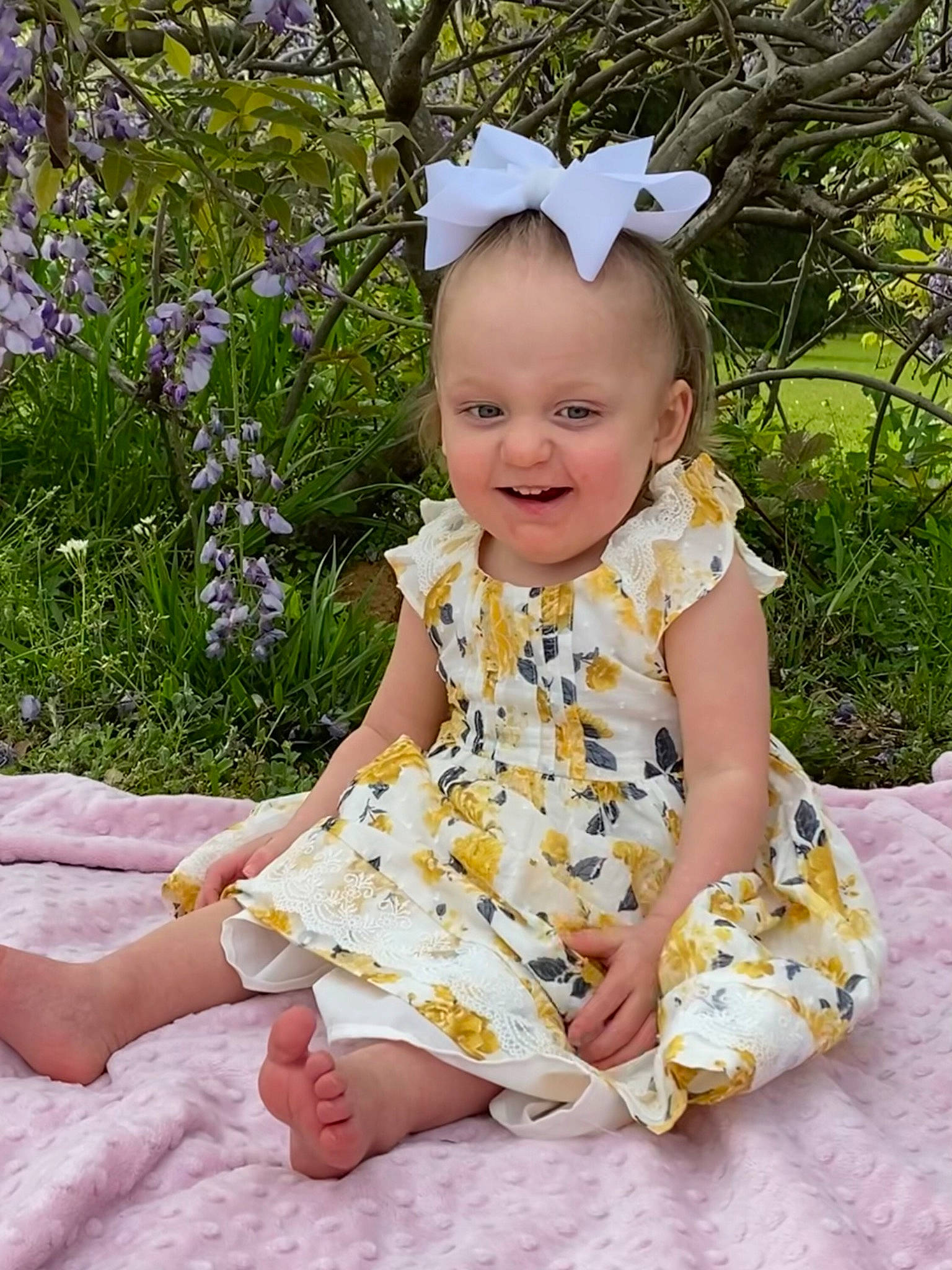 Emma is registered to the contest to win money with this photo: baby, baby_toddler_clothing, child, day_dress, dress, grass, happy, headband, headpiece, jewellery, pattern, people_in_nature, person, pink, plant, purple, skin, sleeve, smile, toddler