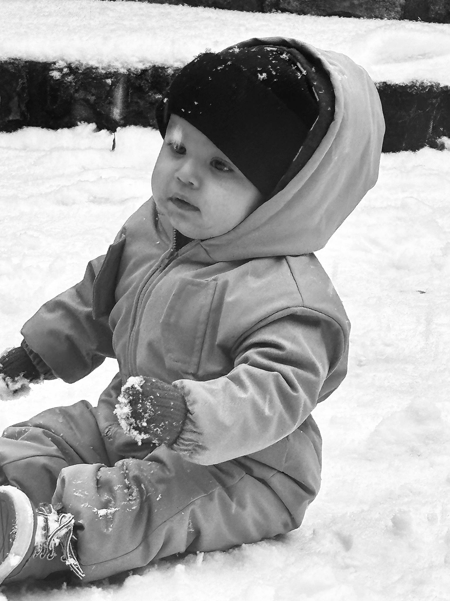 Zakaria participe au concours pour gagner de l'argent avec cette photo : beanie, black, cap, child, freezing, fun, glove, grass, happy, headwear, hoodie, jacket, monochrome, monochrome_photography, person, playing_in_the_snow, recreation, sitting, snow, toddler