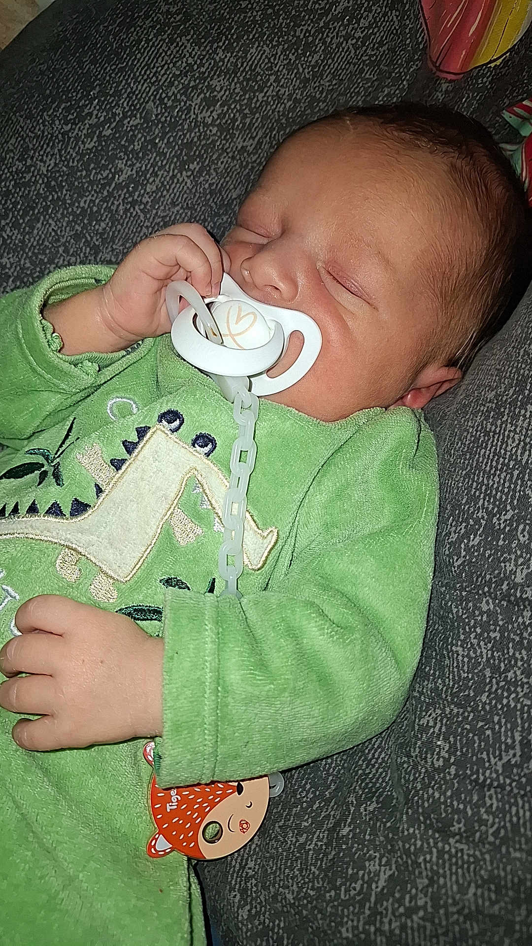 Kalys participe au concours pour gagner de l'argent avec cette photo : baby, sleeping, pacifier, green_clothing, onesie, hand, face, infant, child, resting, cute, soft_texture, indoor, cozy, peaceful, closeup, person, head, young, comfort