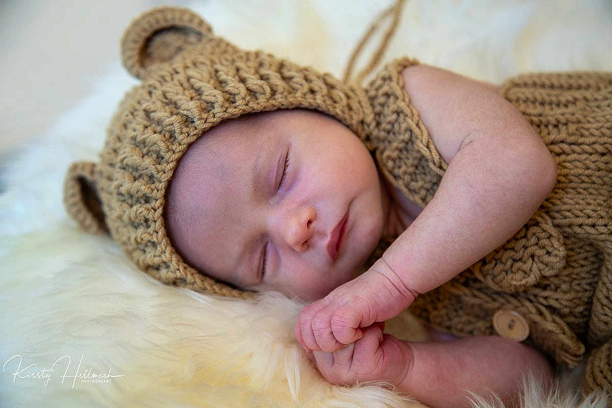 Xavier is registered to the contest to win money with this photo: baby, sleeping, knitted_hat, knitted_outfit, bear_ears, infant, cute, cozy, soft_texture, fluffy_surface, peaceful, resting, portrait, closeup, child, newborn, hand, skin, warm, adorable